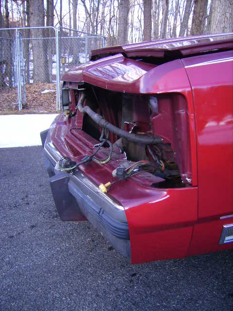 1988 Ford Crown Victoria LTD - The front end of a red 1988 Ford Crown Victoria LTD shows significant damage, with exposed wiring and missing components.