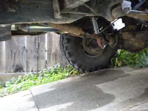 1989 Ford Bronco - Close-up of vehicle undercarriage, focusing on the rear tire and suspension system.