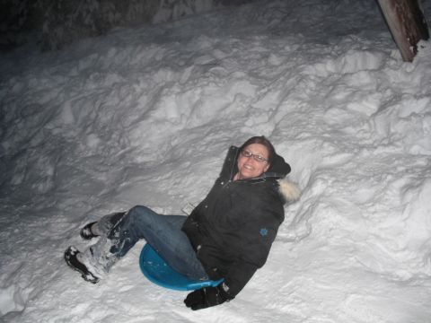 1991 Ford Bronco - A woman enjoys a snowy day by sledding down a snow-covered hill.