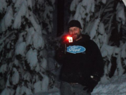 1991 Ford Bronco - A man stands in a snowy forest at night, holding a camera with a red light.