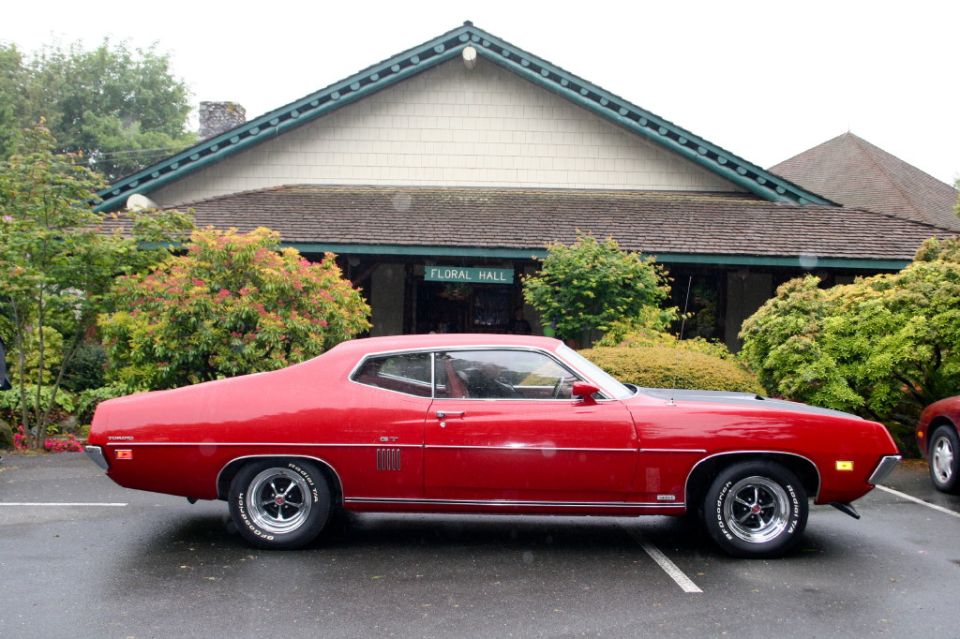 Red Ford Torino GT fastback side view on Magnum 500 wheels with Radial T/A tires