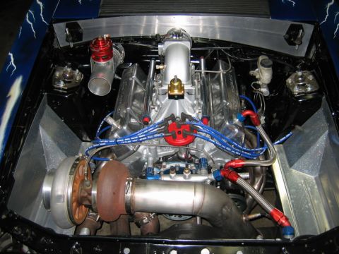 1992 Ford Mustang - Custom V8 engine with a turbocharger and braided fuel lines, set against a blue fender with lightning graphics.