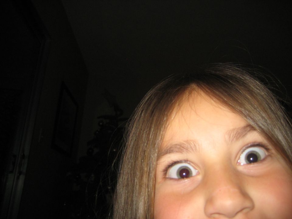 Child's face with wide eyes and brown hair, looking up