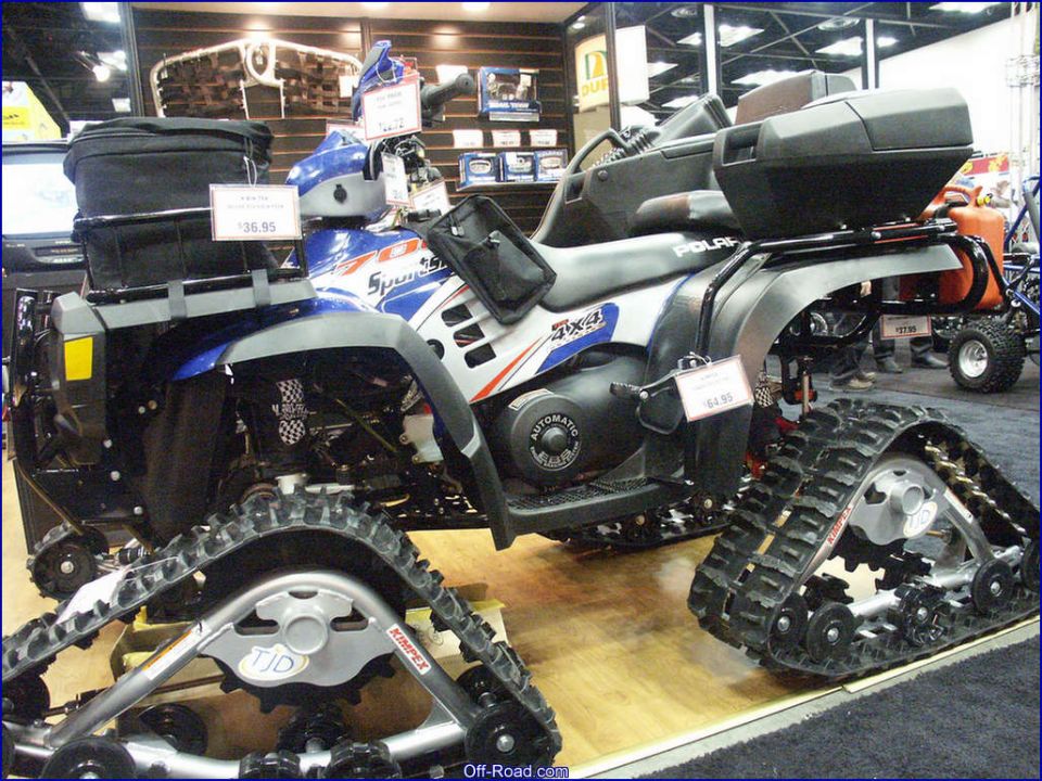 Polaris Sportsman ATV with rubber track conversion kits at indoor show
