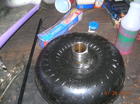 1985 Ford Bronco - A torque converter sits on a workbench with other items, dated 01.26.2010.
