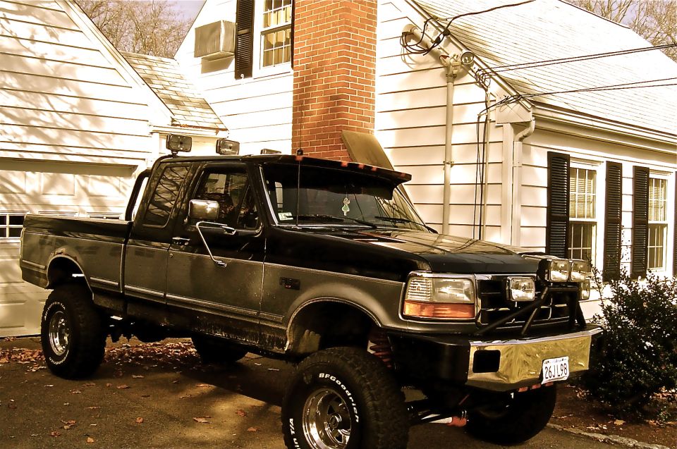 Black and silver 1995 Ford F-150 pickup truck, front 3/4 view