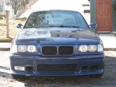 1994 Ford Probe - The front grille and headlights of a blue BMW are visible in this photo.