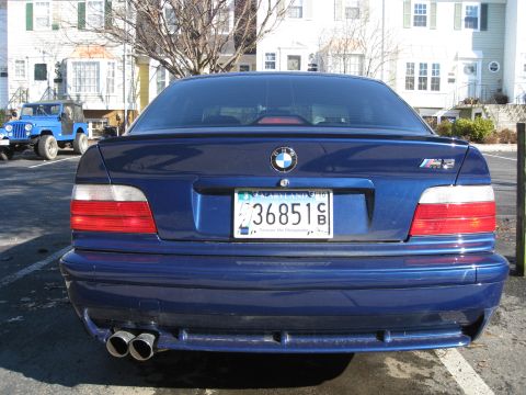1994 Ford Probe - Rear view of a blue BMW M3, quad exhaust pipes and an M3 badge on the trunk lid.