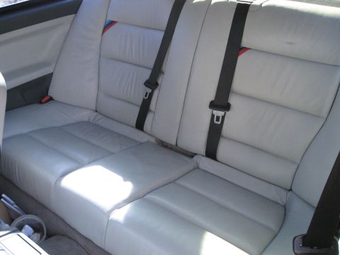 1994 Ford Probe - Interior view of light gray leather rear car seats with visible seatbelts and a colorful stripe detail.