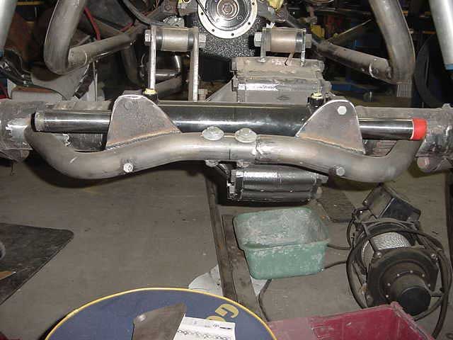 Close-up of vehicle's steering linkage and front axle components, possibly during a repair or modification
