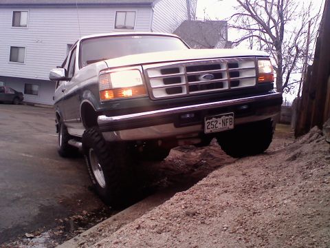 1996 Ford Bronco - 1996 Ford Bronco parked on a dirt incline with lifted suspension.