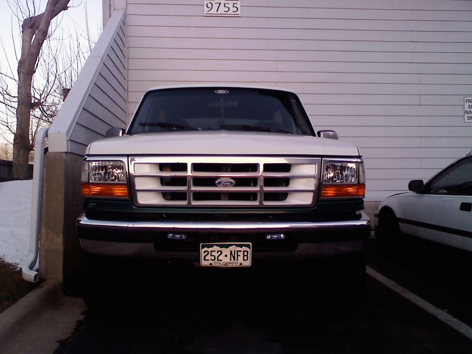 1996 Ford Bronco front view with white grille and green lower body. License plate reads 252-NFB