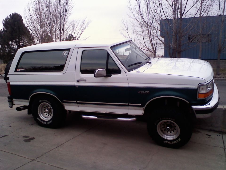 White and green 1996 Ford Bronco side view with aftermarket wheels