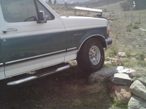 1996 Ford Bronco - A 1996 Ford Bronco is shown from a three-quarter front angle, navigating over rocks.