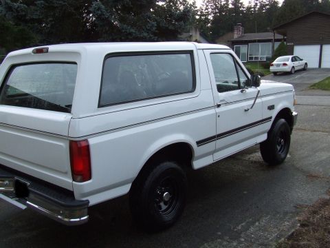 1996 Ford Bronco - A white Ford Bronco is parked in front of a house and garage.