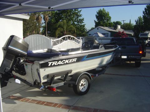 1968 Ford Mustang - A Tracker boat on a trailer is hitched to a pickup truck in a driveway.