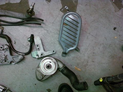 1992 Ford Bronco - Various engine components and hoses are laid out on a concrete surface.
