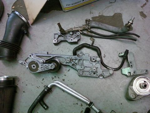 1992 Ford Bronco - Various engine components are displayed on a workshop floor, suggesting a repair or rebuild.