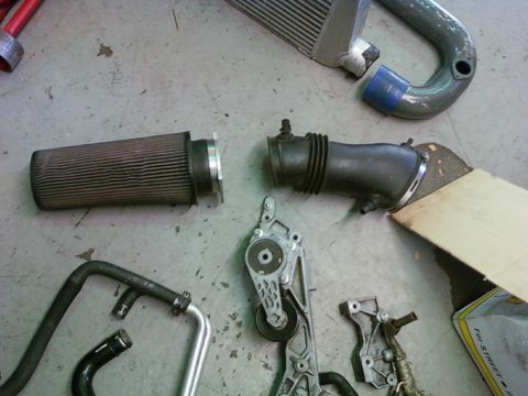 1992 Ford Bronco - Various engine components are disassembled and arranged on a workshop floor.