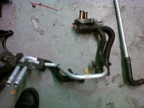 1992 Ford Bronco - These are heater core hoses and a metal pipe lying on a concrete floor.