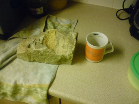 1989 Ford Bronco - A rock and a mug sit on a kitchen counter next to a folded towel.