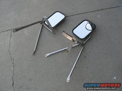 1979 Ford Bronco - Two side mirrors with chrome arms and black trim are displayed on a concrete surface.