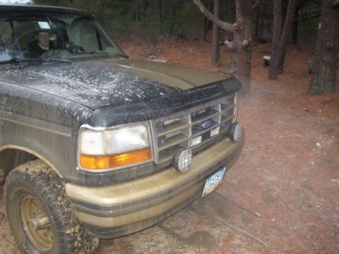 1994 Ford Bronco - This Ford Bronco, likely from the early to mid-1990s, is covered in dirt and parked off-road.