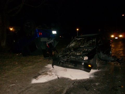 1996 Ford Bronco - Scene of a nighttime car accident involving two vehicles, one of which is overturned.
