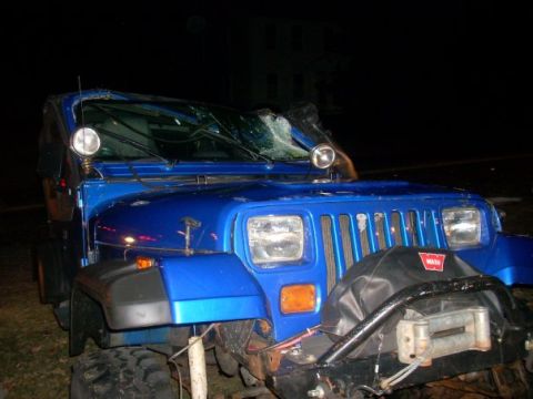 1996 Ford Bronco - Damaged blue Jeep Wrangler after an accident, front view shows broken windshield and winch.