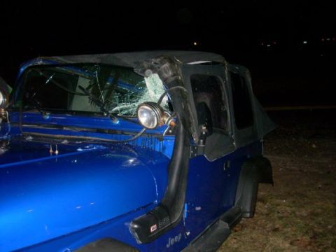 1996 Ford Bronco - A blue Jeep Wrangler with a damaged windshield and a snorkel attachment is seen at night.