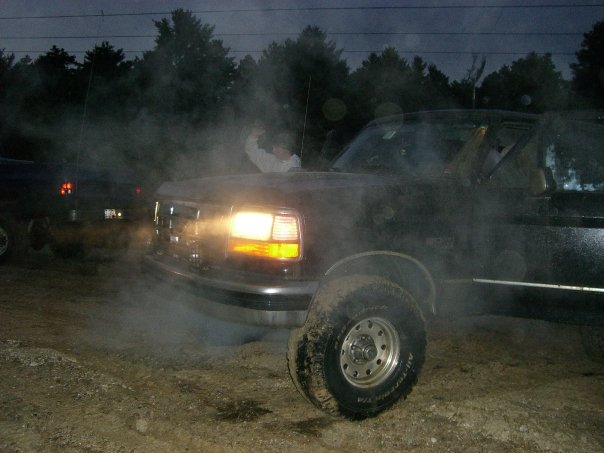 1994 Ford Bronco 3q front view with smoke and headlights on