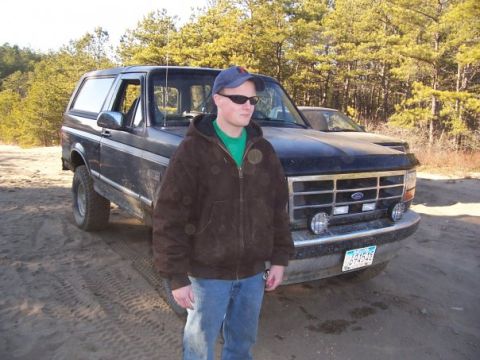 1994 Ford Bronco - A black 1994 Ford Bronco is shown from a 3/4 front view with a person standing in front of it.