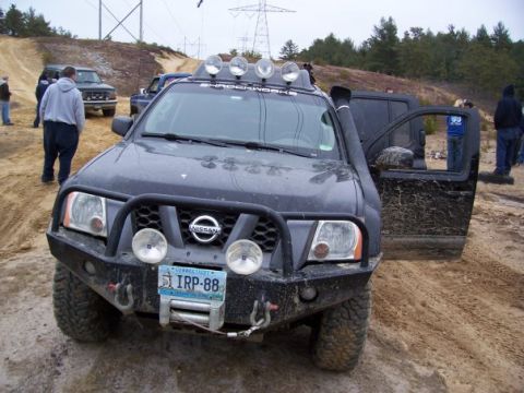 1994 Ford Bronco - Modified Nissan Xterra parked off-road with other vehicles and people present.