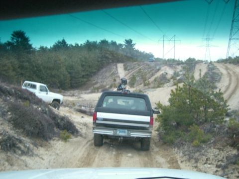 1994 Ford Bronco - A black and silver Ford Bronco navigates a dirt trail with another white vehicle on a hillside.