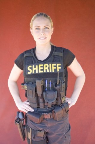 1991 Ford Crown Victoria - A woman poses in tactical gear, complete with a vest, duty belt, and holsters.