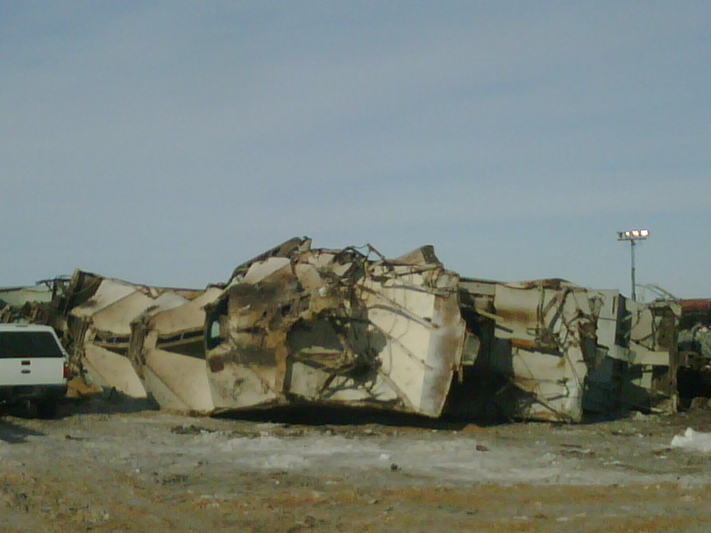 Pile of mangled, crushed train cars under a clear sky