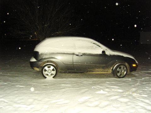 2007 Ford Mustang - A car sits partially buried in snow during a winter night.