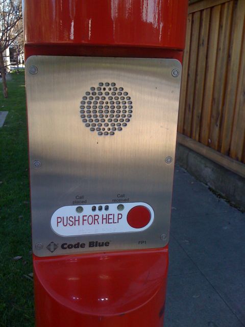 1968 Ford Mustang - A red emergency call box with a metal faceplate, speaker, and a large red button to call for assistance.