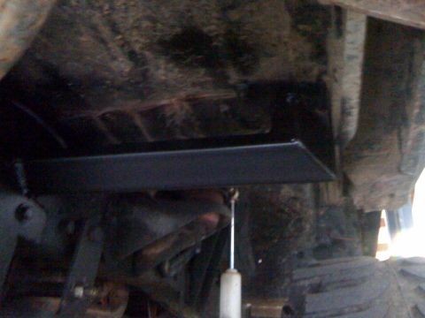 1979 Ford Bronco - Underside view of a vehicle showing a newly installed roll cage component.