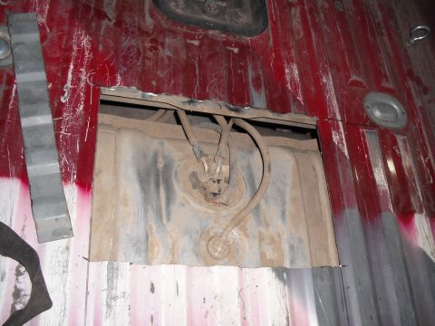 1991 Ford Bronco - View of the fuel tank and associated lines through an access panel opening in the truck bed.