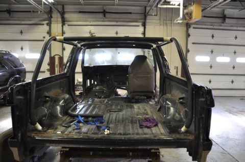 1996 Ford Bronco - Interior view of a stripped-down 1992 Ford Bronco with a custom roll cage.