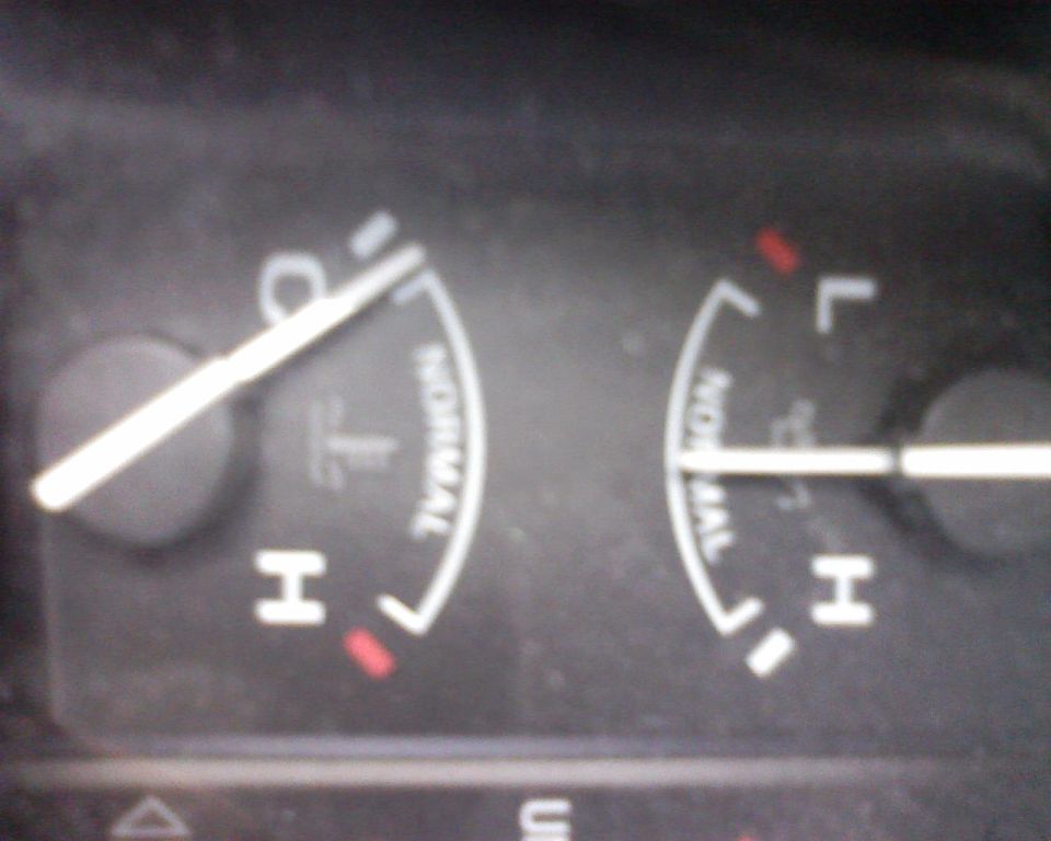 Close-up of a vehicle's gauge cluster showing temperature and fuel levels