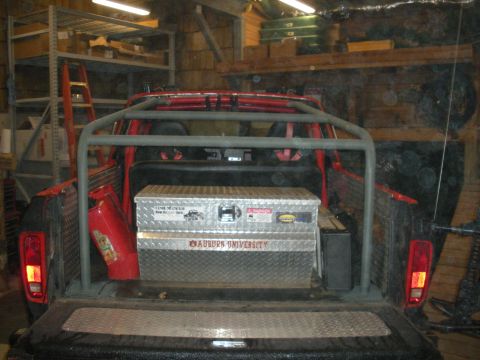 1979 Ford Bronco - A red truck bed is fitted with a roll cage and a diamond plate toolbox displaying 'Auburn University' text.