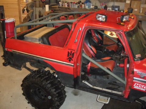 1979 Ford Bronco - This modified off-road vehicle has a prominent roll cage and racing seats, suggesting it is not a standard 1979 Ford Bronco.