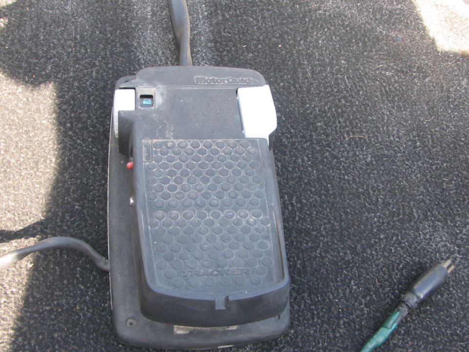 Black MotorGuide trolling motor foot pedal with Tracker tread on gray boat carpet