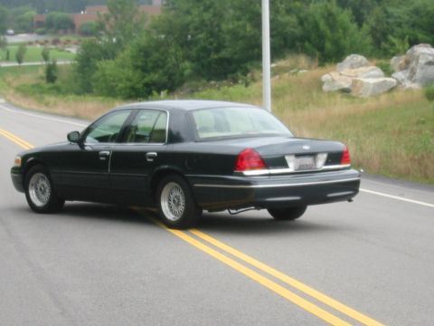 1998 Ford Crown Victoria - Rear view of a 1998 Ford Crown Victoria on a two-lane road.