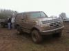 1996 Ford Bronco - Muddy 1996 Ford Bronco parked in a field, with another vehicle partially visible.