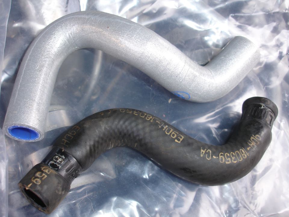 Two radiator hoses, one silver and one black, with text visible on the black hose