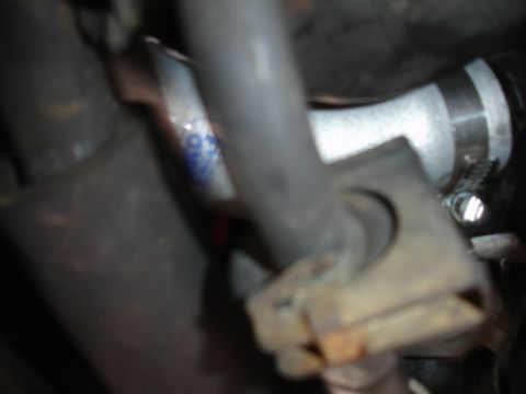 1993 Ford Taurus - A close-up view of a hose clamp and some engine components, with faint blue text visible.