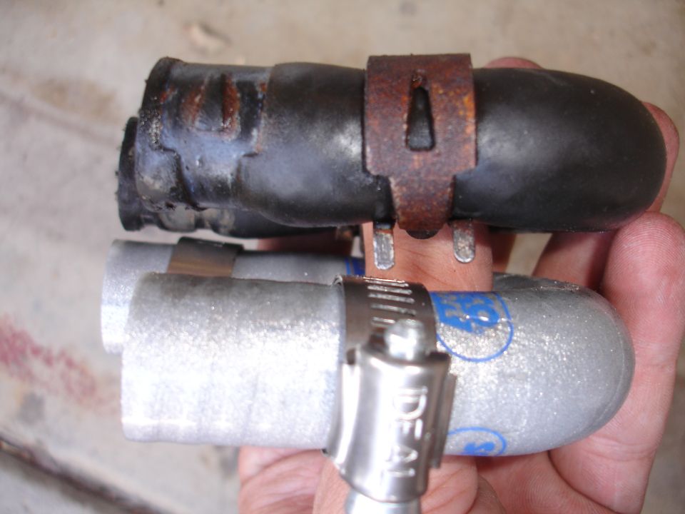 Close-up of two hoses, one black and worn, the other silver with blue markings and an IDEAL clamp